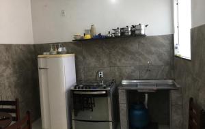 uma pequena cozinha com um lavatório e um frigorífico em Casas do Matteo - 2ª Praia em Morro de São Paulo