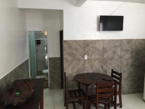 uma sala de jantar com uma mesa e uma televisão na parede em Casas do Matteo - 2ª Praia em Morro de São Paulo