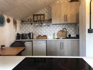 eine Küche mit Geräten aus Edelstahl und einem Tisch in der Unterkunft Cosy cottage near Hartland Village in Bideford + 12 Fotos