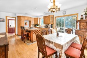 a kitchen with wooden cabinets and a table with chairs at Quiet place in the heart of Laurentides in Sainte-Lucie-de-Doncaster