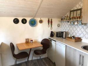 eine Küche mit einem Tisch, Stühlen und einem Waschbecken in der Unterkunft Cosy cottage near Hartland Village in Bideford
