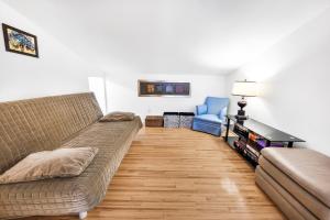 ein Wohnzimmer mit einem Sofa und einem Stuhl in der Unterkunft Quiet place in the heart of Laurentides in Sainte-Lucie-de-Doncaster