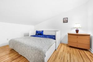 ein weißes Schlafzimmer mit einem Bett und einer Kommode in der Unterkunft Quiet place in the heart of Laurentides in Sainte-Lucie-de-Doncaster