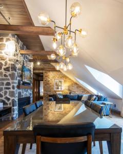 a dining room with a stone wall and a chandelier at La Maison Kent - Par Les Lofts Vieux-Québec in Quebec City