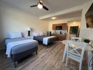 um quarto com duas camas e uma mesa e uma cozinha em Unit 19 Maui Ohana Modern Studio em Wailuku