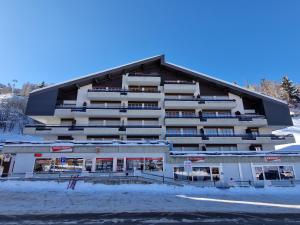 a large building with snow in front of it at Appartement Savoleyres 30 in La Tzoumaz