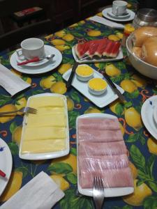 una mesa con platos y utensilios sobre un colorido mantel en Casa da Lu en Olinda