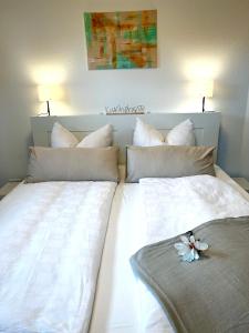 a large white bed with pillows and a flower on it at Apartment Klabautermann in Neubukow