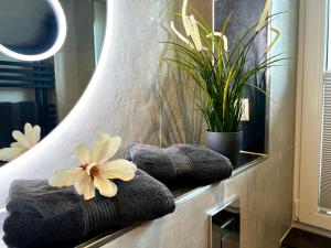a bathroom with towels and a flower on a shelf at Apartment Klabautermann in Neubukow