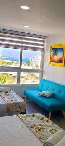 sala de estar con sofá azul y ventana en Apartamentos Ingrid, en San Andrés