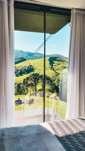 um quarto com uma grande janela com vista em Cabana Romântica na Região dos Lagos em Rio dos Cedros