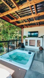 uma banheira de hidromassagem numa sala de estar com tecto em madeira em Cabana Romântica na Região dos Lagos em Rio dos Cedros