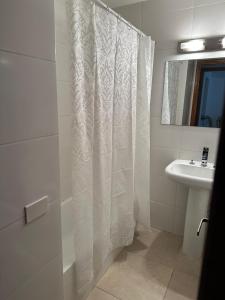 a bathroom with a shower curtain and a sink at Hotel Club de La Barra in Punta del Este