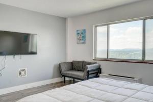 a bedroom with a bed and a chair and a television at Newly Renovated 1 Bedroom Apartment near Downtown in Gadsden