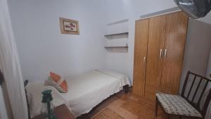 1 dormitorio pequeño con 1 cama y armario de madera en La Toscana en Salta
