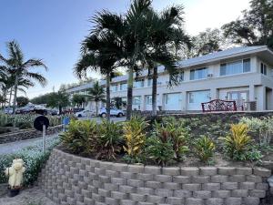 un gran edificio blanco con palmeras delante en Unit 5 Maui Ohana Modern Studio, en Wailuku