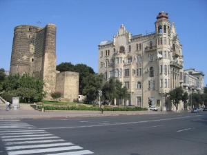a large white building with two towers on a street at Qiz Galasi Hotel Baku in Baku
