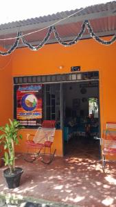 an orange building with chairs sitting outside of it at LUNA del DESIERTO TATACOA in Villavieja