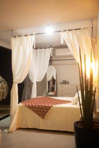 1 dormitorio con 1 cama con cortinas y espejo en RECANTO DA GRATIDÃO, en Laguna