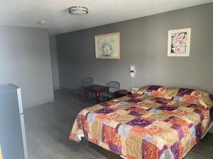 a bedroom with a bed and a table and chairs at Hoosier Travel Lodge in Jeffersonville