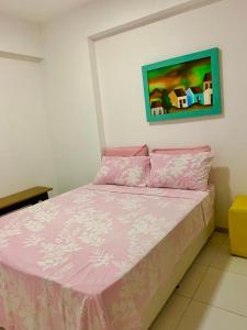 a bedroom with a pink bed with a painting on the wall at Apto moderno e bem localizado in Recife +23 photos