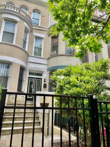 a house with a black fence in front of it at Classy Victorian Brownstone Subway Shopping in Washington