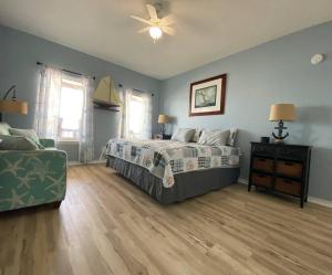 ein Schlafzimmer mit einem Bett, einem Sofa und einem Ventilator in der Unterkunft Beach House with Ocean view in Surfside Beach