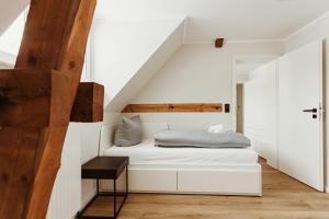 ein Schlafzimmer mit einem weißen Bett im Dachgeschoss in der Unterkunft Harzchalet an der Brockenbahn 2B in Elend