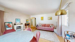 - un salon avec une table et un canapé rose dans l'établissement Abitaziun Ruinatsch 19A - St Moritz, à Saint-Moritz