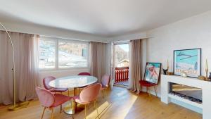 - un salon avec une table, des chaises et une cheminée dans l'établissement Abitaziun Ruinatsch 19A - St Moritz, à Saint-Moritz