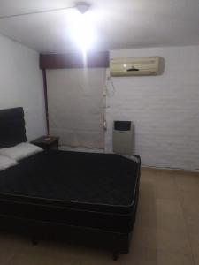 1 dormitorio con cama negra y ventilador en BARRIO alto verde a 10 minutos del aeropuerto 2 dormitorios a cuadras del Orfeo, 5 minutos del kempes en Córdoba