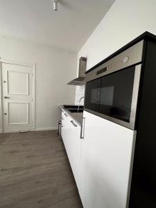 a kitchen with a black and white appliance at Hidden Gem next to TU Delft Campus Family XL house in Delft