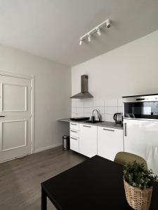 une cuisine avec des appareils blancs et une table noire dans l'établissement Hidden Gem next to TU Delft Campus Family XL house, à Delft