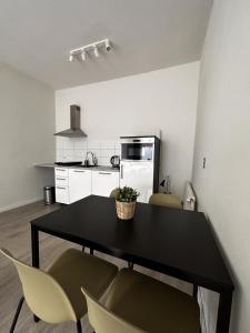 uma cozinha com uma mesa preta e duas cadeiras em Hidden Gem next to TU Delft Campus Family XL house em Delft