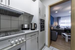 een keuken met een fornuis bovenste oven naast een woonkamer bij DEHOME - Laguna - Stay by Central Station in Koblenz
