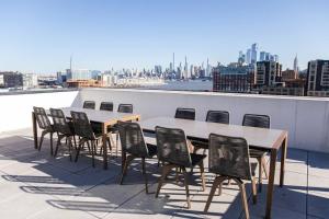 a table and chairs on the roof of a building at Dharma Home Suites Hoboken in Hoboken