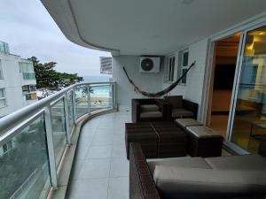 - Balcón con sofá y sillas en un edificio en Lanai Apart Hotel, Flat Moderno com Vista Mar no Posto 2 da Barra B1-0031, en Río de Janeiro
