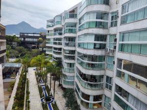 un edificio alto con palmeras delante en Lanai Apart Hotel, Flat Moderno com Vista Mar no Posto 2 da Barra B1-0031, en Río de Janeiro