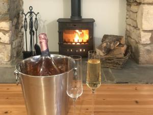 two glasses of wine in front of a fireplace at The Street Cottage in Uley