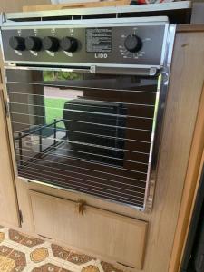 a toaster oven in a kitchen with its door open at Back Beach Retro Van in Fingal