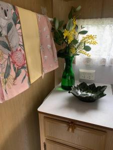 a green vase with flowers on top of a counter at Back Beach Retro Van in Fingal