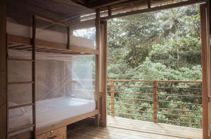 Guachaca的住宿－Mendihuaca Surf Camp，客房设有双层床和大窗户。