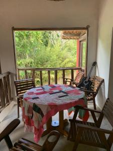 Pousada Raízes Guaramiranga في غواراميرانغا: غرفة مع طاولة و غيتار على شرفة
