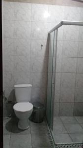 a bathroom with a toilet and a shower stall at Pousada Raízes Guaramiranga in Guaramiranga