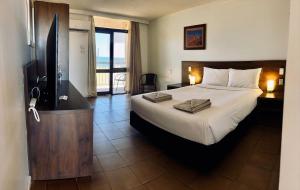 a hotel room with a bed and a television at Hedland Hotel in Port Hedland