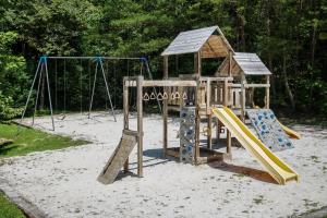 a wooden playground with a slide and swings at Sky View Mountain Dream in Gatlinburg