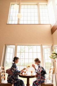 two women sitting at a table in a room at Agri In Holiday in Hirosaki