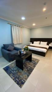 sala de estar con cama y sofá azul en ذوق الخيال للشقق المخدومة Dhoq Alkhayal en Al Ahsa
