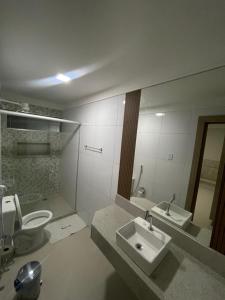 uma casa de banho com um lavatório, um WC e um espelho. em Mustang Hotel em Salgueiro