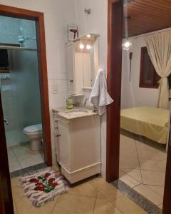 uma casa de banho com um lavatório, um WC e um chuveiro em Sol poente em Florianópolis